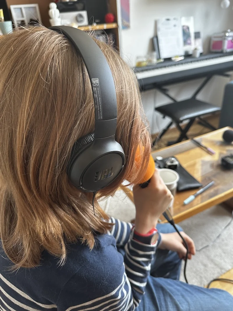 Jeune fille de dos parle au micro Jeune fille de dos parle au micro et témoigne pour un podcast